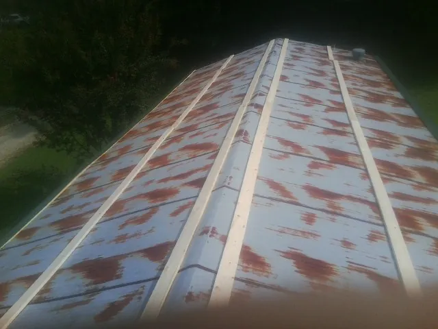 Rusted metal roof panels with new wood purlins before replacement — Storm Damage Roof Repair in Blodgett Mills by Roofing Brothers